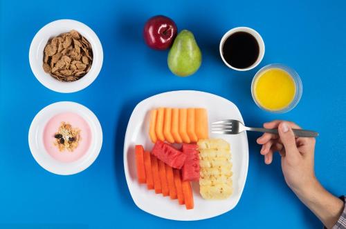 a plate of fruit and vegetables on a blue table at One Villahermosa 2000 in Villahermosa