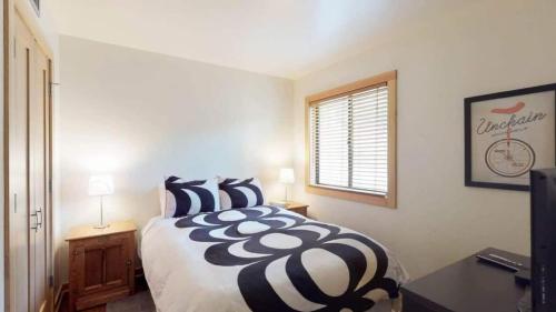 una camera da letto con un letto con cuscini bianchi e neri di Sockeye by AvantStay Modern 2 BR Condo w Access to Northstar Resort Community a Kingswood Estates