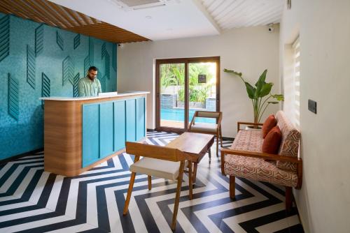 a man standing at a bar in a living room at Hotel Amaiti by stayxp in Puducherry