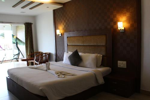 a hotel room with a bed with slippers on it at Vgp Golden Beach Resort in Chennai