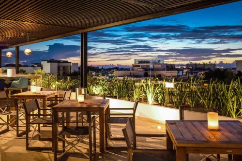 a patio with tables and chairs and a view of the city at Fiesta Inn Playa del Carmen in Playa del Carmen