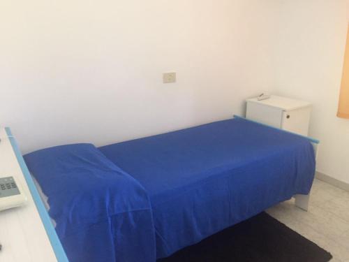 a bed with a blue blanket in a room at Villa Petrusa in Stromboli