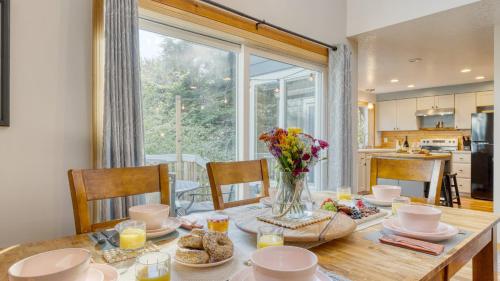 a dining room table with a vase of flowers on it at Royal Canoe by AvantStay Walk to the Shore Private Yard in Arch Cape