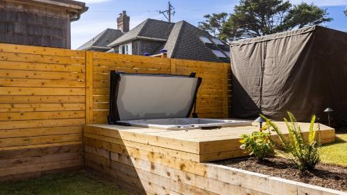 a tv sitting on top of a wooden fence at Royal Canoe by AvantStay Walk to the Shore Private Yard in Arch Cape