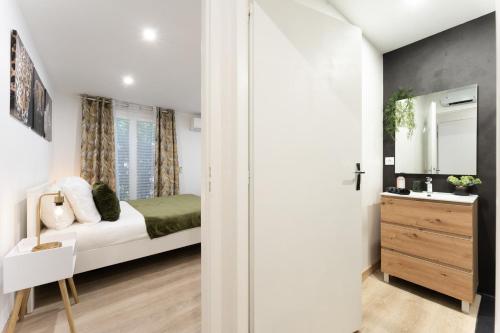 a small bedroom with a bed and a sink at Studio 27m² sur la Côte Pavée avec parking privé in Toulouse