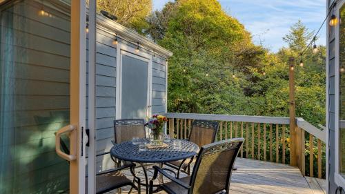 a patio with a table and chairs on a deck at Royal Canoe by AvantStay Walk to the Shore Private Yard in Arch Cape