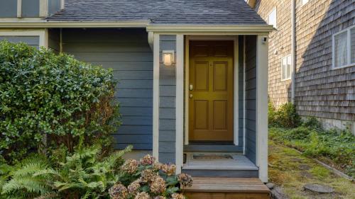 a yellow door on a house with a porch at Royal Canoe by AvantStay Walk to the Shore Private Yard in Arch Cape