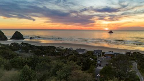 a view of a beach at sunset with rocks in the water at Royal Canoe by AvantStay Walk to the Shore Private Yard in Arch Cape
