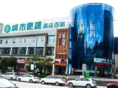 un edificio con auto parcheggiate di fronte di City Comfort Inn Liupanshui Sports Center a Shuicheng