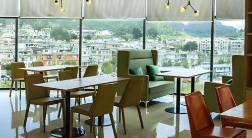 un ristorante con tavoli e sedie e una grande finestra di City Comfort Inn Liupanshui Sports Center a Shuicheng