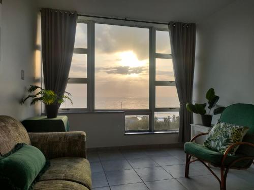 a living room with a couch and a large window at Peacehaven's Finest View 107 in Scottburgh