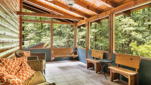 a screened in porch with a couch and a table at Twin Creeks Lodge by AvantStay 33 Acre Retreat in Brevard