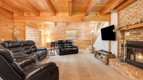 a living room with leather furniture and a fireplace at Twin Creeks Lodge by AvantStay 33 Acre Retreat in Brevard