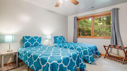 a bedroom with a blue bed and a window at Twin Creeks Lodge by AvantStay 33 Acre Retreat in Brevard