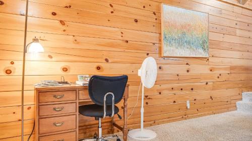 a desk and a chair in a room with wooden walls at Twin Creeks Lodge by AvantStay 33 Acre Retreat in Brevard