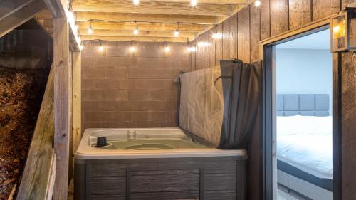 baño pequeño con bañera y cama en Amber Refresh by AvantStay Pool and Hot Tub, en Jefferson City