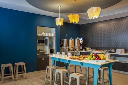 a blue kitchen with a table with fruit on it at One Monterrey Tecnologico in Monterrey