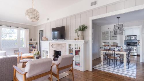 a living room with a fireplace and a dining room at Topaz By AvantStay Adorable Cottage Walking Distance to Beach w Large Patio in San Diego