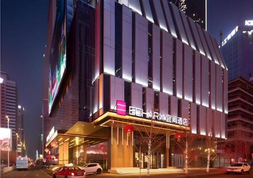 a building on a street with cars parked in front of it at Echarm Hotel Shenyang Zhongjie North Station Metro Station in Shenyang