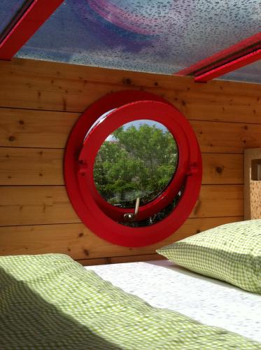 a bedroom with a red mirror on the wall at Pavillon "CASSIOPÉE" in Rosnay