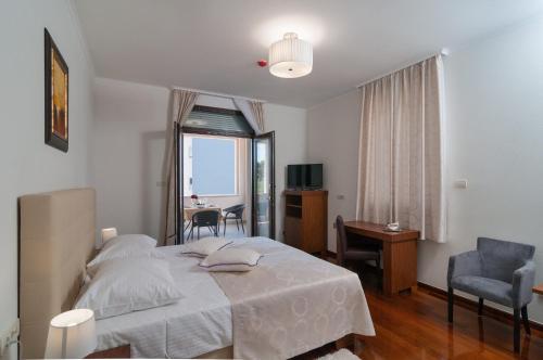 a bedroom with a bed and a desk and a window at Luxury Rooms Near the Beach in Split
