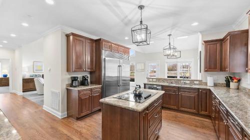 a large kitchen with wooden cabinets and stainless steel appliances at Lake Escape by AvantStay Lakefront Private Dock in Mooresville