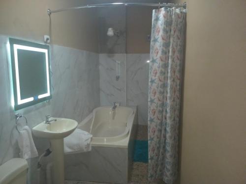 a bathroom with a sink and a tub and a shower at Cabañas La China in El Congo