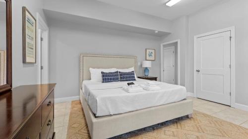 a white bedroom with a large bed and a dresser at Lake Escape by AvantStay Lakefront Private Dock in Mooresville