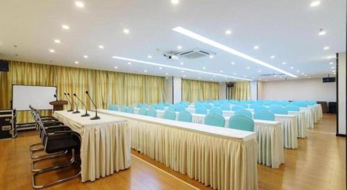 a room with rows of tables and blue chairs at Xana Hotelle Jinan Wuanfu Interchange Huafu International Square in Jinan