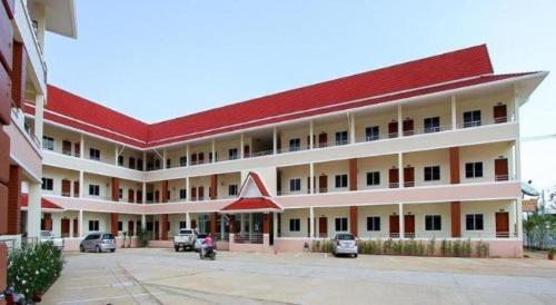 a large white building with a red roof at SC Palace Chiangrai Hotel in Chiang Rai