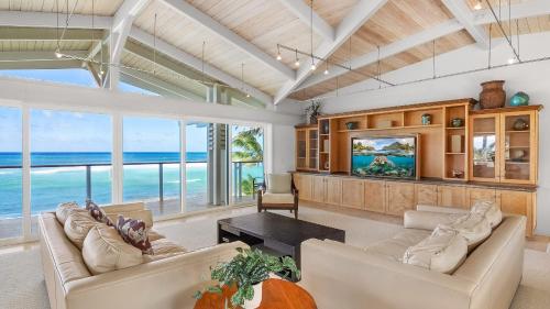 a living room with a view of the ocean at Beachfront Retreat w Ocean Views Bikes Balconies Ocean Haven by Avantstay in Haleiwa