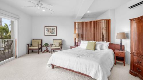 a bedroom with a large bed and two chairs at Beachfront Retreat w Ocean Views Bikes Balconies Ocean Haven by Avantstay in Haleiwa