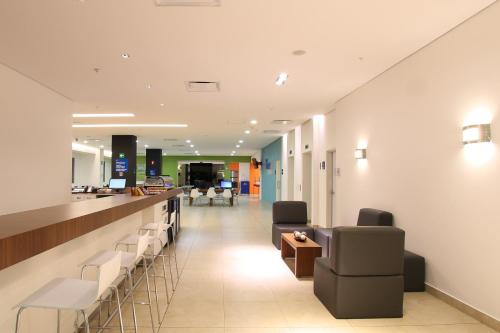 a lobby with chairs and a bar in a hospital at One Cuernavaca in Cuernavaca