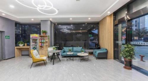 a lobby of a building with chairs and tables at GreenTree Inn Express Zhangjiagang Hexing Town Shazhou Professional Institue of Technology in Qiwei