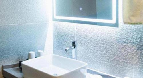 a white bathroom with a sink and a mirror at GreenTree Inn Express Datong High-Speed Railway Station Wanda Plaza Fangte in Datong