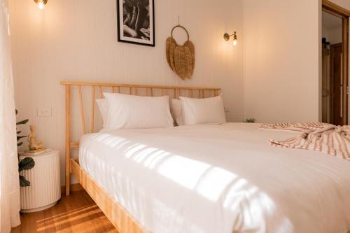 a bedroom with a large bed with white sheets at Bay Hideaway Stieglitz in Saint Helens Island