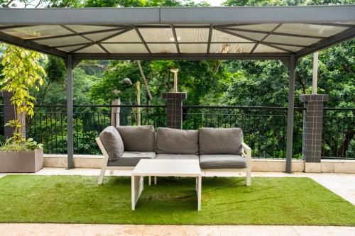 a couch sitting under a pergola on a lawn at Residence MASSOU in Yaoundé