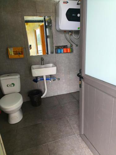 a bathroom with a toilet and a sink at Homestay Quản Thanh in Loung Co