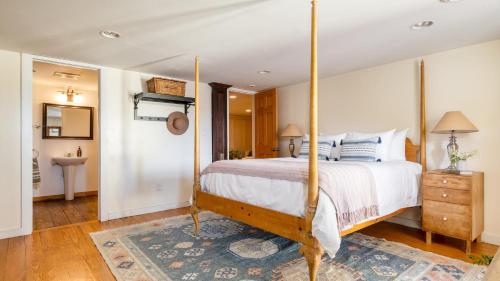 a bedroom with a canopy bed and a bathroom at River House by AvantStay Historic Secluded Estate on the Hudson River w Pool Sleeps 24 in Hudson
