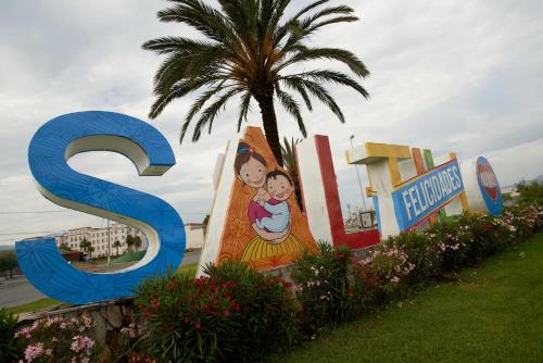 a large sign for a resort with a palm tree at One Saltillo Aeropuerto in Saltillo