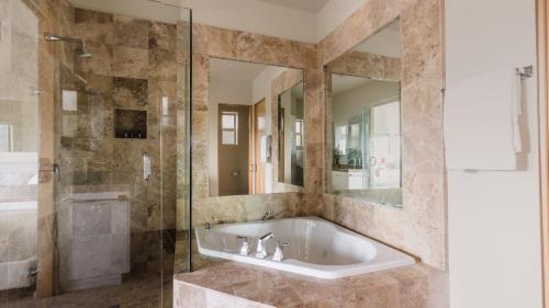 a bathroom with a tub and a glass shower at Seascape by AvantStay Spacious Contemporary Oasis in Del Mar in San Diego