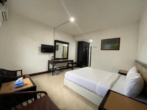 a hotel room with a bed and a desk at Hotel Riau Holidays in Tanjung Pinang 