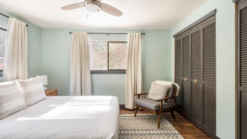 une chambre avec un lit, une chaise et une fenêtre dans l'établissement Quiet River Bend Cabin by AvantStay 35 Mins to Mt Bachelor 10 Mins to Town Centre Hot Tub, à Bend