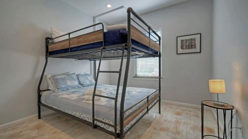 a bedroom with two bunk beds in a room at 6BDR Bay Haven w Shared Waterfront Pool Boat Dock Keeper Trout by AvantStay in Padre Island