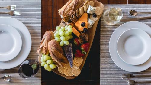 a plate of food on a table with grapes and bread at Klamath by AvantStay Premier Lakeside Cabin w Spa Fire Pit Lake Views in Bend