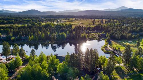 an aerial view of a lake with trees and mountains at Klamath by AvantStay Premier Lakeside Cabin w Spa Fire Pit Lake Views in Bend