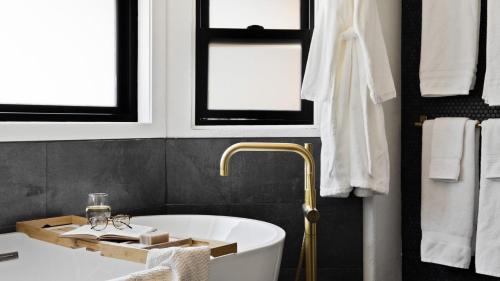 a bathroom with a tub and a sink and windows at Roca Roja by AvantStay Mountain Views in the Heart of Sedona in Sedona