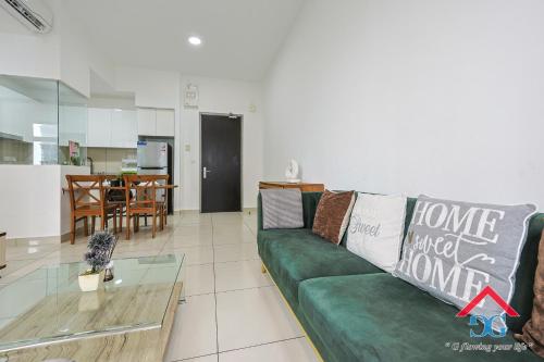 a living room with a green couch and a table at Astoria Ampang By Grabstay in Kuala Lumpur