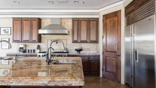 a kitchen with wooden cabinets and a sink at Sunbeam by AvantStay Elegant Private Desert Home w Infinity Pool Spa View in Cave Creek