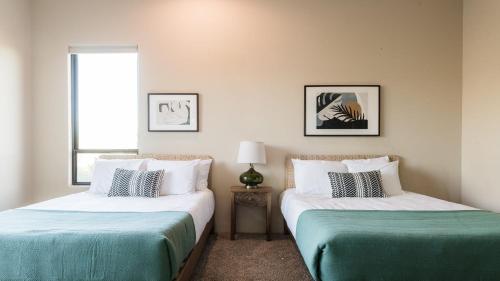 two beds sitting in a room with a window at Sunbeam by AvantStay Elegant Private Desert Home w Infinity Pool Spa View in Cave Creek